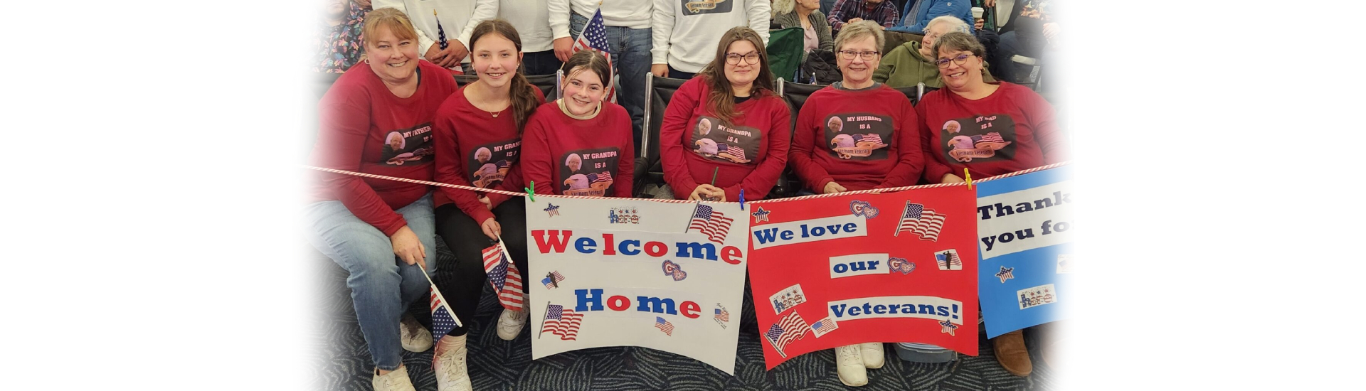 Family holds signs for their veteran