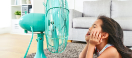 girl laying on floor in front of fan