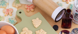 spritz cookies plain and with red and green sprinkles surrounded by cooking ingredients