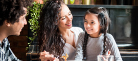 happy family sitting in kitchen with child on moms lap