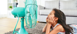 child laying in front of fan