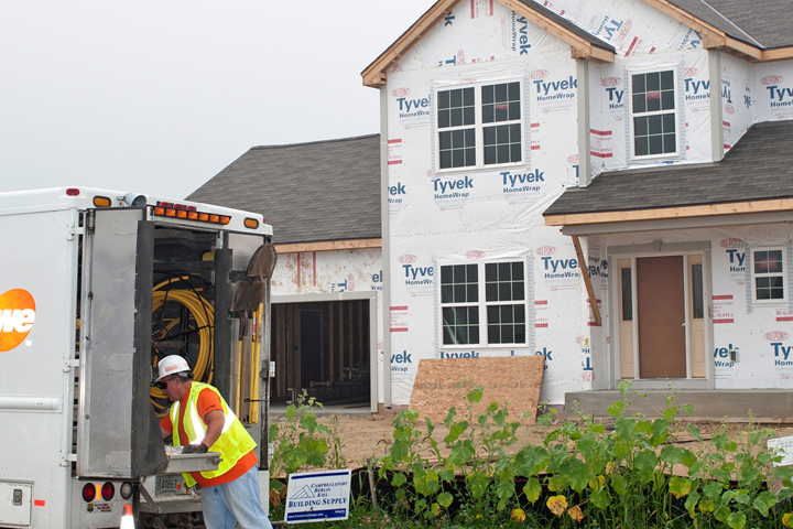 we energies employee with truck in front of a new home that is being constructed